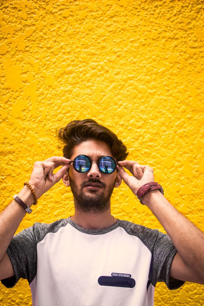 Man wearing premium sunglasses against a bright wall