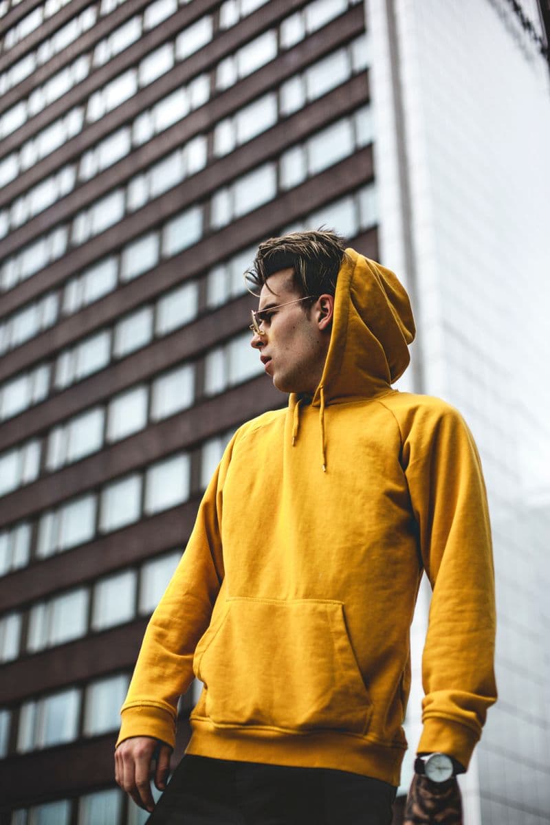 Man in a relaxed mustard hooded sweatshirt