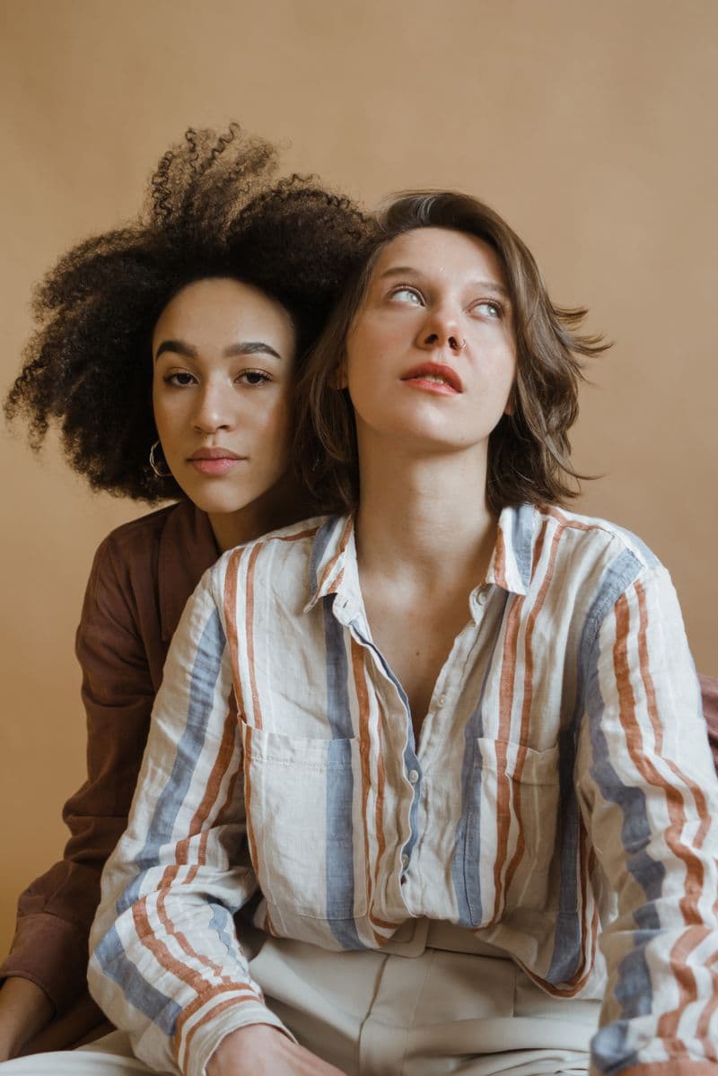 Two women in coordinated shirts and knitwear