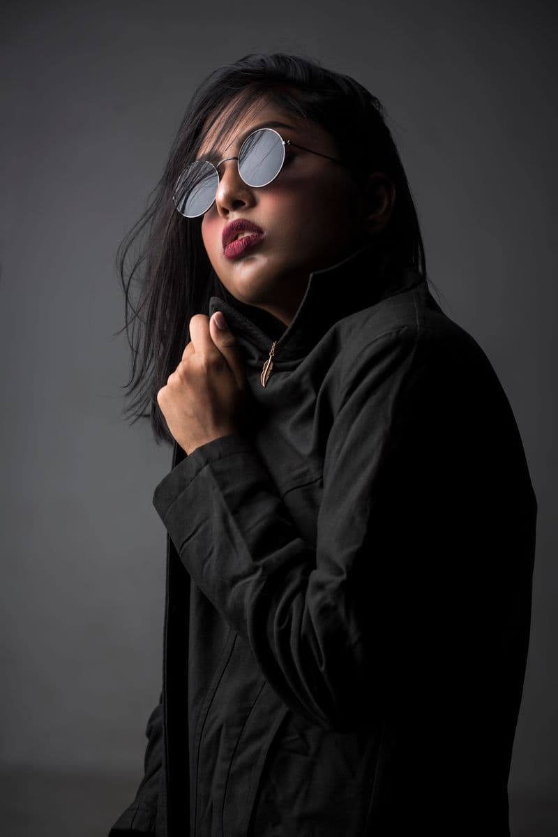 Person in a sleek black outfit and sunglasses