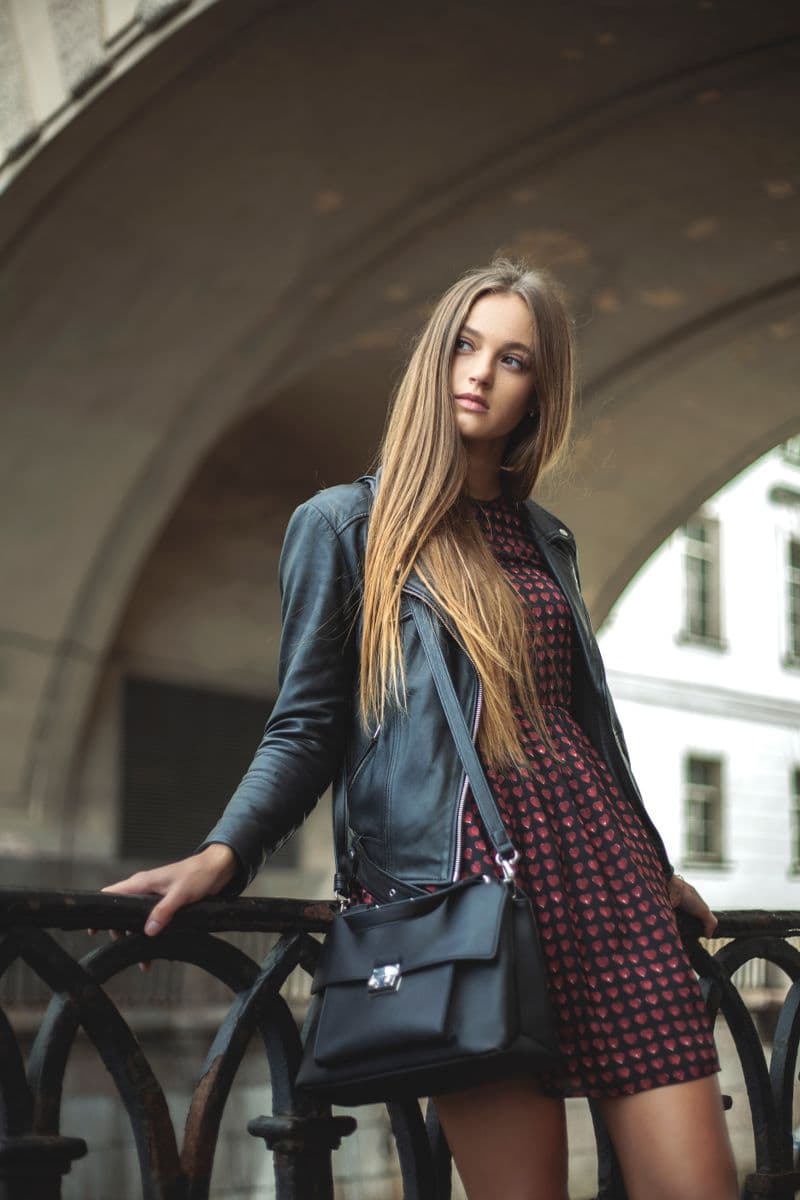 Woman in a leather jacket and skirt in the city